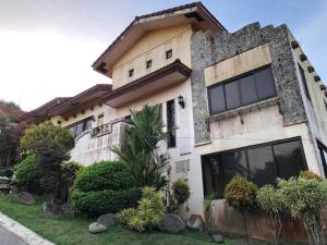 uma casa com uma grande janela do lado em Tagaytay BNR Guesthouse 4BR With Balcony 12-14 Guest em Tagaytay