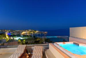 a balcony with a swimming pool and two chairs at Angelique Luxury apartment in Agios Nikolaos