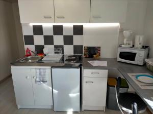 a small kitchen with a sink and a microwave at studio ''tulipe'' dans le Berry in Les Bordes