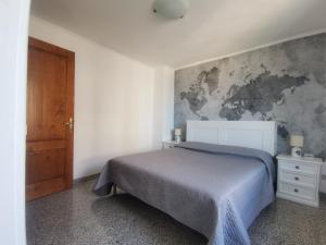 ein Schlafzimmer mit einem Bett und einer Karte an der Wand in der Unterkunft Appartamento La terrazza in Baunei