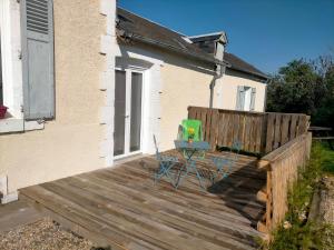 a wooden deck with two chairs and a table on it at studio ''tulipe'' dans le Berry in Les Bordes