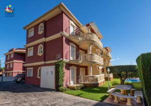 a red building with a bench in front of it at Apartamentos Madeira Casa Azahar in Alcossebre