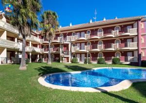 a large building with a swimming pool in front of it at Apartamentos Madeira Casa Azahar in Alcossebre
