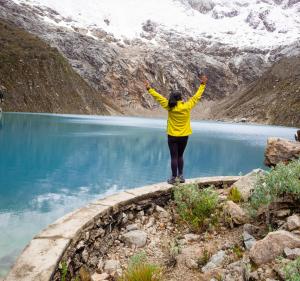 a woman standing on a ledge near a body of water at Taulli Guest in Marcará