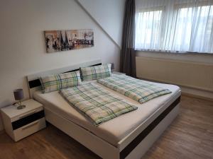 una camera da letto con un grande letto con lenzuola bianche di Pension am Wald a Gössweinstein