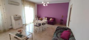 a living room with purple walls and a couch and a table at Il Gabbiano al Capo in Palermo