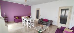 a living room with purple walls and a table and chairs at Il Gabbiano al Capo in Palermo