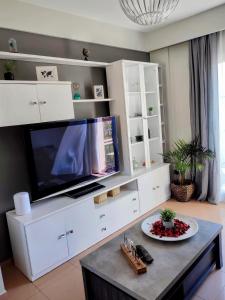 - un salon avec une télévision sur un centre de divertissement blanc dans l'établissement Apartamento turístico Azahara, à Nerja