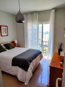- une chambre avec un lit et une grande fenêtre dans l'établissement Apartamento turístico Azahara, à Nerja