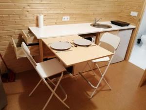 eine winzige Küche mit Spüle, Tisch und Stühlen in der Unterkunft Monte do Carmo in Encarnação