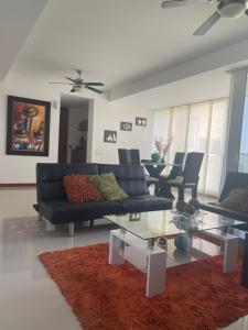 uma sala de estar com um sofá e uma mesa de vidro em Apartamento Condominio Zazue Santa Marta em Santa Marta