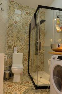 un bagno con WC e lavatrice di Luna´s home. Precioso loft en Bollullos par del Condado a Bollullos par del Condado Altre 11 foto