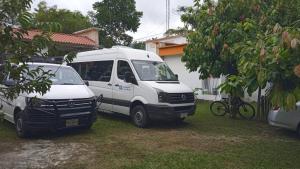 zwei weiße Vans vor einem Haus geparkt in der Unterkunft Ciudad de Las Rocas in La Fortuna Gallo Giro