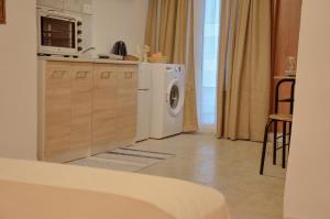 a kitchen with a washing machine and a microwave at Vel Boutique Suites in Agia Galini