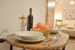 een tafel met een fruitschaal en een fles wijn bij Vel Boutique Suites in Agia Galini