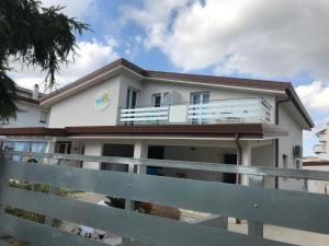 a white house with a fence in front of it at IL CUCCO B&B in Ginosa Marina
