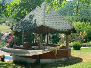 a gazebo with a hammock and a roof at Crossroads Preseka in Pluzine