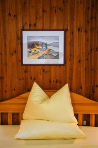a bed with a pillow and a picture on the wall at Steinerhof in Braies