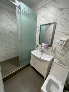 W łazience znajduje się umywalka i lustro. w obiekcie RAMZIYA NUR Guest house w Samarkandzie