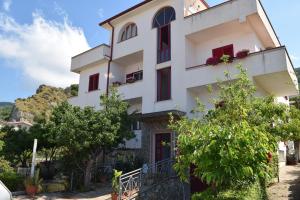 a white building with trees in front of it at Mare e Terme a Guardia Piemontese in Guardia Piemontese Terme