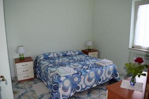 a bedroom with a bed with a blue and white comforter at Mare e Terme a Guardia Piemontese in Guardia Piemontese Terme