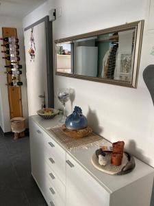 um armário branco com um espelho em cima em Haus VALLESIA em Saas-Fee
