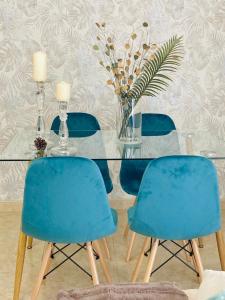 a dining room with blue chairs and a glass table at Lovely New Home in Granada