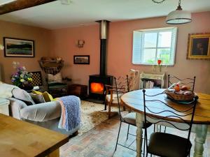 a living room with a table and a wood stove at Horseshoe Cottage Greyabbey in Greyabbey