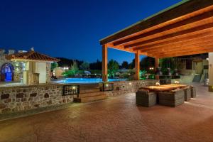um pavilhão com uma mesa e uma piscina à noite em Casa Loma em Triánta