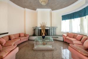 a living room with pink couches and a table at Casa Loma in Ialysos