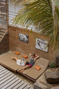 two women laying on a bed on a patio at Eco Lodge Mancora in Máncora