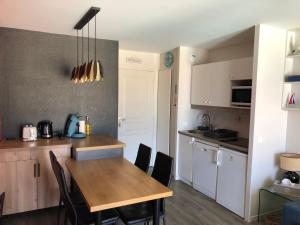 a kitchen and dining room with a table and chairs at Très bel appartement vue mer avec piscine in Douarnenez
