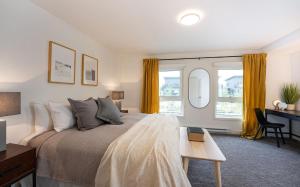 a bedroom with a bed and a desk and windows at Revelation Retreat by Revelstoke Vacations in Revelstoke