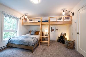 a bedroom with two bunk beds and a window at Revelation Retreat by Revelstoke Vacations in Revelstoke