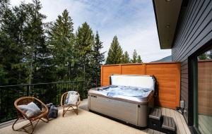 レベルストークにあるRevelation Retreat by Revelstoke Vacationsの家のバルコニーにホットタブがあります。