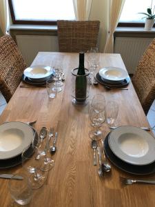 a wooden table with plates and glasses and a bottle of wine at Ferienhaus Treis in Neef