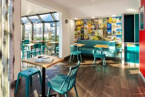 a restaurant with blue chairs and tables and a window at hotelF1 Calais Coquelles in Coquelles