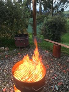 un grand grill avec cheminée devant un banc dans l'établissement ANIMALS GALMPING, à Guasca