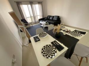 a living room with a table and a couch at Amazing 1 Bedroom Apartment Next To The Beach in Ras al Khaimah