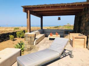 a patio with a couch and a table and a bench at Dammuso Ma.Vi in Pantelleria +55 photos