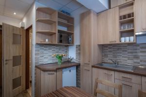 a kitchen with wooden cabinets and a sink and a counter at Byt Staré koliesko, Jasná, Demänovská Dolina in Belá