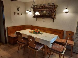 una mesa de comedor con sillas y un jarrón de flores. en Ferienhaus Luise, en Sebnitz