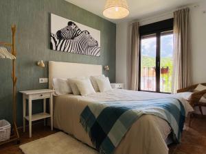 1 dormitorio con 1 cama con una foto de cebra en la pared en Apartamento Rural La Leyenda, en El Bosque