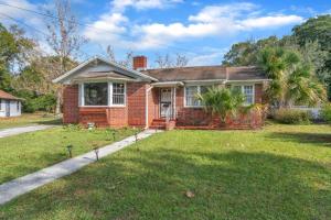 a red brick house with a grass yard at Comfy pet friendly home in Jacksonville mins to downtown’s in Jacksonville