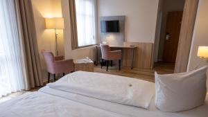 シュテンダールにあるPension Sellentのベッド、テーブル、椅子が備わるホテルルームです。