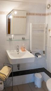 a white bathroom with a sink and a toilet at Pension Sellent in Stendal