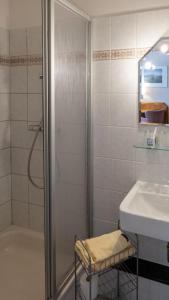 ein Bad mit einer Dusche und einem Waschbecken in der Unterkunft Pension Sellent in Stendal