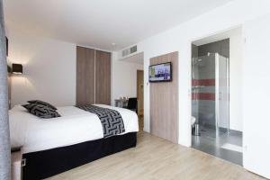 a bedroom with a bed and a bathroom with a television at Tulip Inn Massy Palaiseau - Residence in Palaiseau