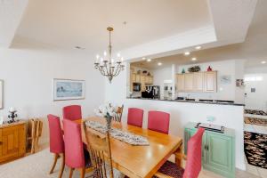 cocina y comedor con mesa de madera y sillas rosas en The Sandbridge Dunes - Serenity 206, en Virginia Beach
