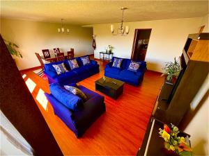 a living room with blue couches and a television at Exclusivo y amplio- Great View in Arequipa